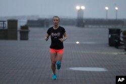 Amelia Gapin, a transgender woman from New Jersey, works out in early morning fog while preparing to run the Boston Marathon during a jog at Liberty State Park in Jersey City, New Jersey, April 18, 2017.