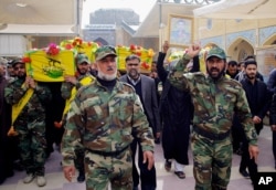 FILE - Mourners carry the coffins of four militia members of a Shiite group, Nujaba movement of Islamic Resistance, during their funeral procession in the Shiite holy city of Najaf, 160 kilometers south of Baghdad, Iraq, Dec. 29, 2015.