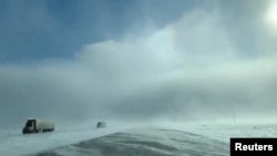 Trucks drive amidst heavy snow near Fargo, North Dakota, U.S., January 29, 2019, in still image taken from a video taken from social media. Carol Bauer/via REUTERS