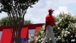A man wears a face covering while using a sidewalk in Mebane, N.C., July 1, 2020.