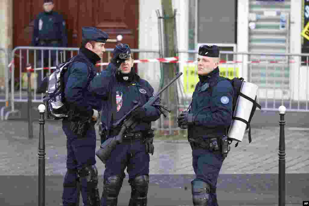Petugas keamanan berpatroli di kasawan Republique Square, Paris (11/1).