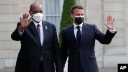 French President Emmanuel Macron, right, welcomes President of the Sudanese Transitional Council General Abdel Fattah al-Burhan, left, for a dinner with leaders of African states, at the Elysee Palace, in Paris, May 17, 2021.
