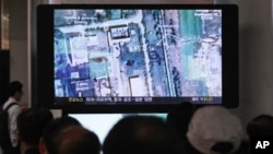 FILE - South Koreans watch a television broadcasting a satellite image of the nuclear facility in North Korea, at the Seoul Railway Station in Seoul, South Korea.