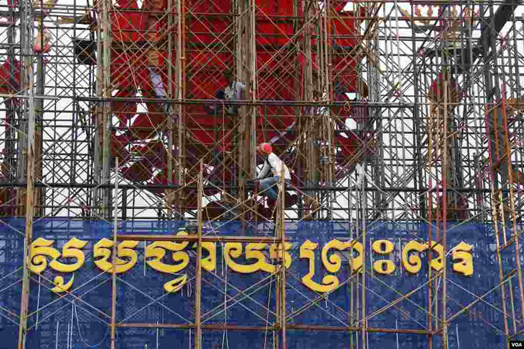 Construction workers in front of the Royal Palace in Phnom Penh prepare the display for the king&#39;s 10th anniversary celebration, October 25, 2014. (Nov Povleakhena/VOA Khmer) 