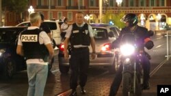 Police officers seal off the area of an attack after a vehicle drove onto the sidewalk and plowed through a crowd of revelers who'd gathered to watch Bastille Day fireworks in the French resort city of Nice, July 15, 2016.