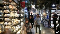 FILE - People walk through the Grand Bazaar where Chinese-made goods have flooded the market, in Tehran, Iran, Sept. 6, 2018. It’s hard not to see China wherever you look in Iran. From Chinese goods to its business people eager for deals as Western business interests flee, Iran likely will further embrace Beijing as an alternative market for its crude oil and financial transactions amid uncertainty over the nuclear deal.