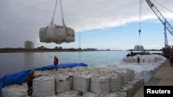 Radnici u luci Heihe u provinciji Heilongjiang, Kina, istovaraju soju uvezenu iz Rusije. (10. oktobar 2018.)