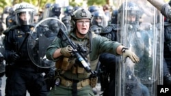 FILE - Police begin to clear demonstrators gathered as they protest the death of George Floyd, near the White House in Washington, June 1, 2020.