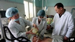 Doctors give attention to a wounded man at a hospital in Bishkek, Kyrgyzstan, Friday, April 9, 2010. Roza Otunbayeva, a former foreign minister who once backed President Kurmanbek Bakiyev and now leads the opposition interim government, visited a Bishke