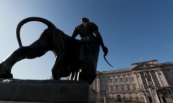 A statue stands in front of Buckingham Palace in London, March 9, 2021. Britain's royal family is absorbing the tremors from a sensational television interview by Prince Harry and the Duchess of Sussex.