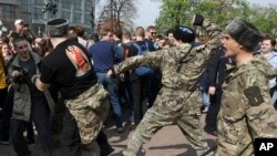 Fighters of National Liberation movement clash with protesters during clashes at a demonstration against President Vladimir Putin in Pushkin Square in Moscow, Russia, Saturday, May 5, 2018. 