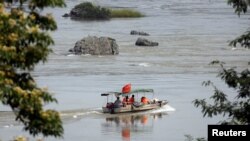 FILE - A Chinese boat with a team of geologists surveys the Mekong River, at the border between Laos and Thailand, April 23, 2017. 