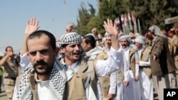 Yemeni prisoners gesture after being released by the Saudi-led coalition, during their arrival at the airport in Sanaa, Yemen, Oct. 15, 2020. 