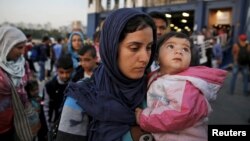 Syrian refugees disembark from a Greek ferry after arriving in the port of Piraeus near Athens, June 14, 2015.