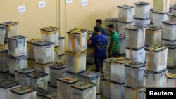 FILE - Employees of the Iraqi Independent High Electoral Commission inspect ballot boxes at a warehouse in Dohuk, Iraq, May 16, 2018. 