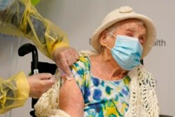 Registered nurse Cynthia Banada, left, administers the Moderna COVID-19 vaccine to Luz Collazo, 103, at Miami Jewish Health, a senior health care facility, in Miami, Dec. 28, 2020.