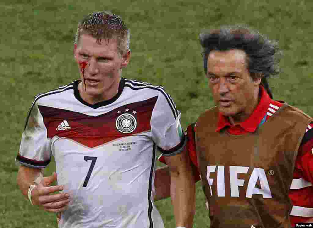 Germany's Bastian Schweinsteiger leaves the pitch after he was injured during extra time at the Maracana stadium in Rio de Janeiro, July 13, 2014.