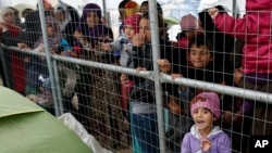 Para migran antri untuk mendapatkan pembagian makanan di kamp pengungsi Idomeni, Yunani (23/3).