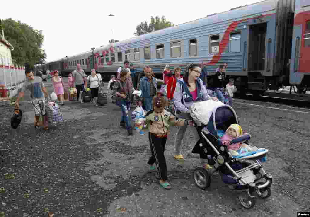 Refugees fleeing the fighting in eastern Ukraine make their way toward a refugee camp, in Stavropol, southern Russia, Aug. 21, 2014.