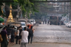 People look at a police vehicle after Sanchaung district has been seized in search of anti-coup demonstrators in Yangon, Myanmar, March 8, 2021.