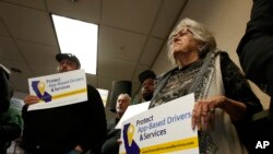 FILE - Drivers show support for a proposed ballot initiative challenging a law that makes it harder for companies to label workers as independent contractors, in Sacramento, Calif., Oct. 29, 2019. Uber and Postmates have now sued to block the law.