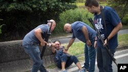 La police brésilienne aide une femme à se relever après des coups de feu échangés avec des trafiquants de drogues. Rio de Janeiro, 31 janvier 2018. 