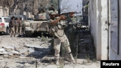Un membre de l'armée nationale libyenne tire lors d'affrontements avec des militants islamistes dans le dernier bastion des militants à Benghazi, Libye, 6 juillet 2017.
