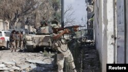 FILE - A member of Libyan National Army fires a weapon during clashes with Islamist militants in the militants' last stronghold in Benghazi, Libya, July 6, 2017.