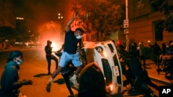 Demonstrators vandalize a car as they protest the death of George Floyd, Sunday, May 31, 2020, near the White House in Washington. Floyd died after being restrained by Minneapolis police officers. (AP Photo/Evan Vucci)