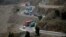 Trucks carry goods on its way to neighboring Afghanistan through the Khyber Pass in Pakistani tribal area, March 21, 2017. A Pakistani border official says hundreds of trucks have crossed into Afghanistan from Pakistan after the border reopened for the fi