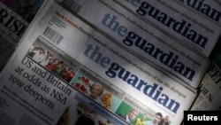 FILE - Copies of the Guardian newspaper are displayed at a news agent in London, Aug. 21 2013.