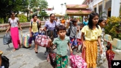 FILE - Ethnic Rakhine villagers arrive at a temporary monastery camp with their belongings, June 29, 2020, in Sittwe, Rakhine State, Myanmar.