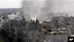 Image made from amateur video released by Shaam News Network and accessed June 8, 2012, purports to show explosions in the Khaldiyeh area of Homs, Syria.
