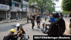 Para demonstran menggunakan ketapel dalam unjuk rasa menentang kudeta militer di Yangon, Myanmar, Minggu, 14 Maret 2021. (Foto: Reuters)