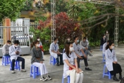 FILE - Health workers wait to be vaccinated against COVID-19 at Hai Duong Hospital for Tropical Diseases, Hai Duong province, Vietnam, March 8, 2021.