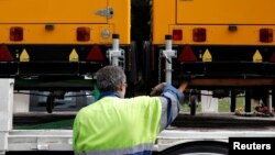 An employee loads lighting towers manufactured by JC Bamford Excavators Ltd. (JCB) at the the JCB France headquarters in Sarcelles, near Paris, France, May 22, 2017. 
