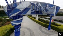 FILE - In this file photo taken Wednesday, March 18, 2020, one of the normally bustling entrances to the Disneyland resort is vacant due to the coronavirus closure in Anaheim, Calif. Disney is postponing the mid-July reopening of its Southern…