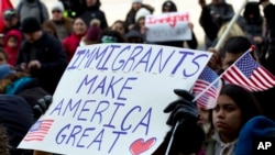 FILE - Supporters of immigrants' rights march in downtown Washington during an immigration protest, Feb. 16, 2017. A group of Hispanic workers is suing a Michigan industrial plant that fired them for taking part in the protest.