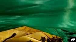 The shadows of demonstrators are cast on a Brazilian flag during a protest demanding the impeachment of Brazilian President Jair Bolsonaro in Brasilia, Brazil, July 24, 2021.