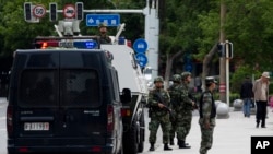 2014年5月23日，中国新疆首府乌鲁木齐的街道上戒备森严，武警部队的装甲车停在街上，武警战士在各处警戒。