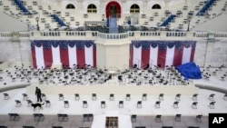 A law enforcement official sweeps a spectator seating area as preparations take place for President-elect Joe Biden's inauguration ceremony at the U.S. Capitol in Washington, Saturday, Jan. 16, 2021. (AP Photo/Patrick Semansky)