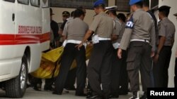 Polisi membawa kantung-kantung jenazah, salah satunya diyakini berisi mayat Santoso, buronan teroris paling dicari di negara ini, di sebuah rumah sakit di Palu, Sulawesi Tengah (19/7). (Foto: Antara)