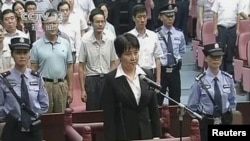 Gu Kailai (C), wife of ousted Chinese politician Bo Xilai, stands at the defendant's dock during her trial at Hefei Intermediate People's Court in this still image taken from video, August 20, 2012. 