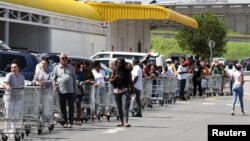 Warga antre untuk membeli barang kebutuhan sehari-hari menjelang kebijakan lockdown di Johannesburg, Afrika Selatan (24/3). 