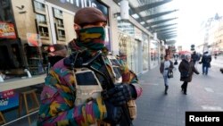Belgian soldiers patrol in central Brussels as police search area during a continued high level of security following the recent deadly Paris attacks, Belgium, Nov. 23, 2015. 