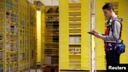 Seorang pekerja di gudang barang Amazon di Bretigny-sur-Orge dekat Paris, Prancis (foto: ilustrasi). 