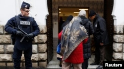 FILE - French police stand next to the entrance of Paris Mosque as French Muslims arrive for Friday prayers in Paris.