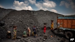 Indian laborers load coal into a truck in Dhanbad, an eastern Indian city in Jharkhand state, Friday, Sept. 24, 2021. (AP Photo/Altaf Qadri)