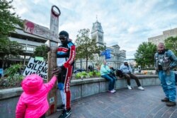 A Louisville protest leader holds a wooden crucifix in Jefferson Square Park on Oct. 2, 2020, in Louisville, Kentucky. The park has remained the epicenter for Black Lives Matter protest action following the March 13 killing of Breonna Taylor.