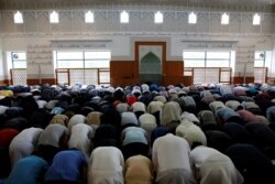 FILE - Men pray at the Grand Mosque of Copenhagen, a Sunni house of worship popular with residents of nearby Mjolnerparken, in Copenhagen, Denmark, May 11, 2018.